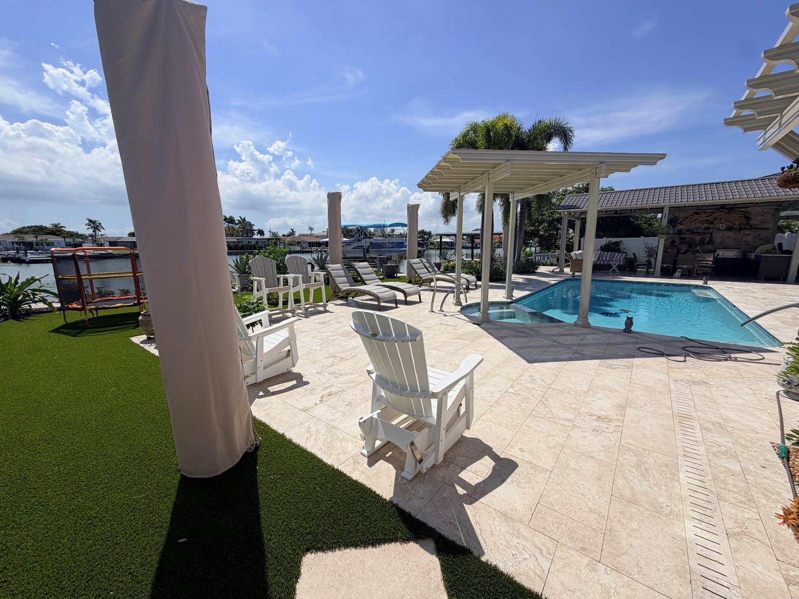 Completed Clearwater poolside patio with artificial turf lawn and waterfront seating
