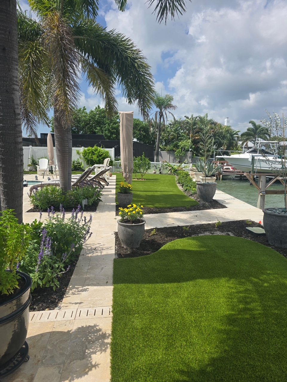 Finished artificial turf strips between the walkway, planting beds and waterfront at the Clearwater home