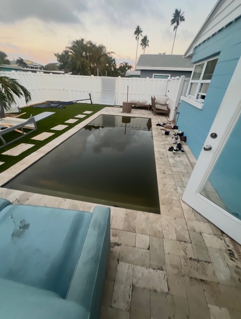 Pool and surrounding backyard after the 2024 storms, with the turf visible along the pool