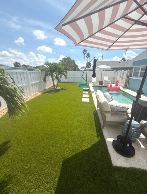 Refreshed artificial turf beside a clean pool in the Florida backyard