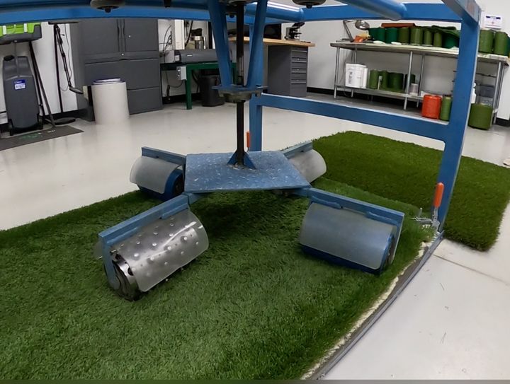 Lab equipment crush-testing a turf sample for quality control