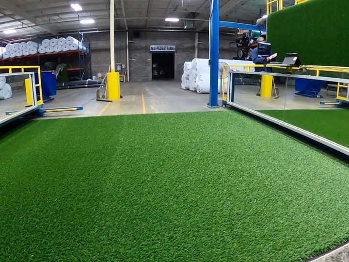 Wide view of the EverBlade factory floor with finished turf and roll racks