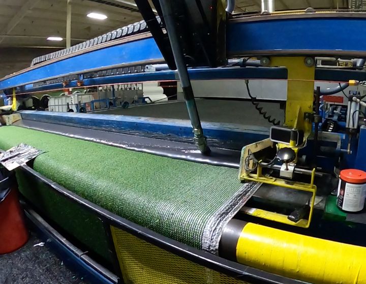 Tufting machine stitching turf backing at the EverBlade factory
