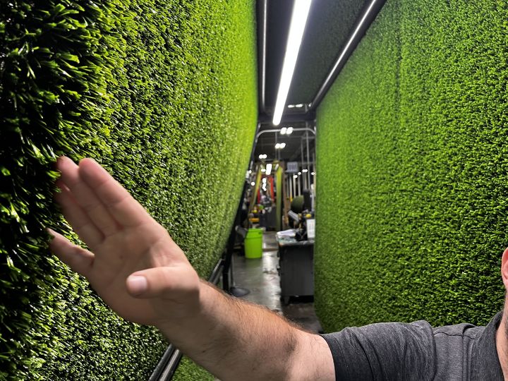 Rolls of finished turf lining the factory floor aisle