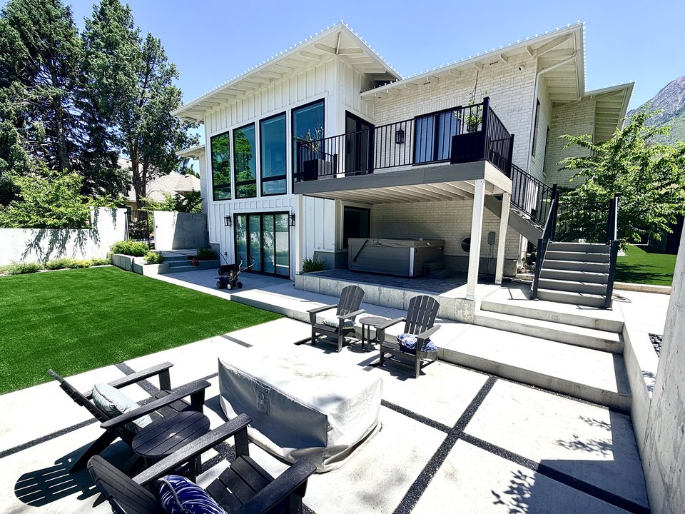 Modern paver patio and fire pit beside a finished turf lawn