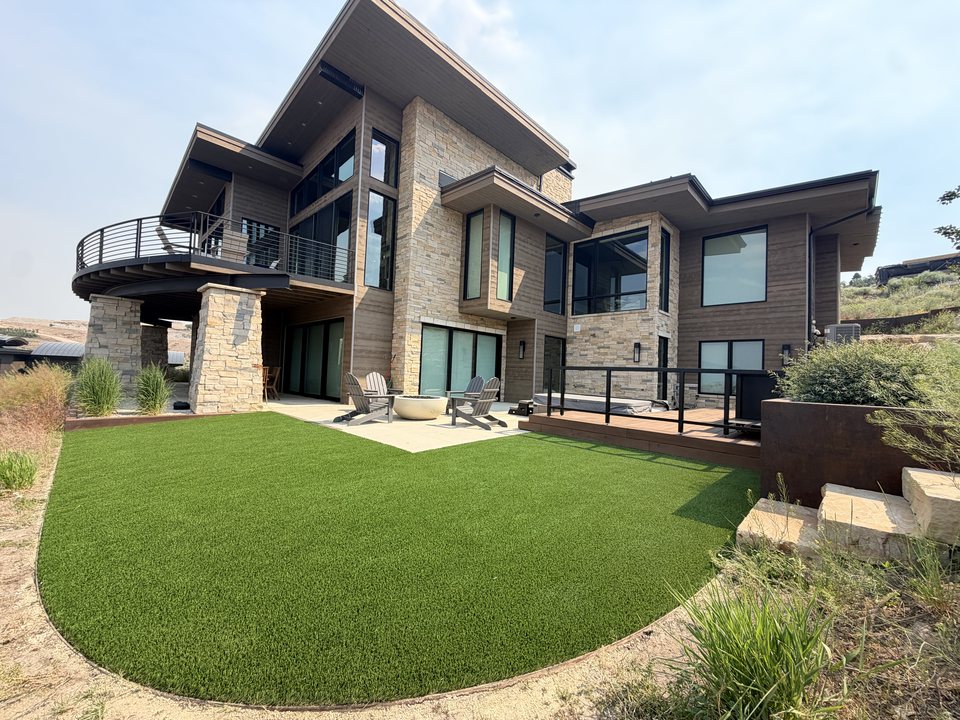 Modern backyard with a shaped artificial turf lawn