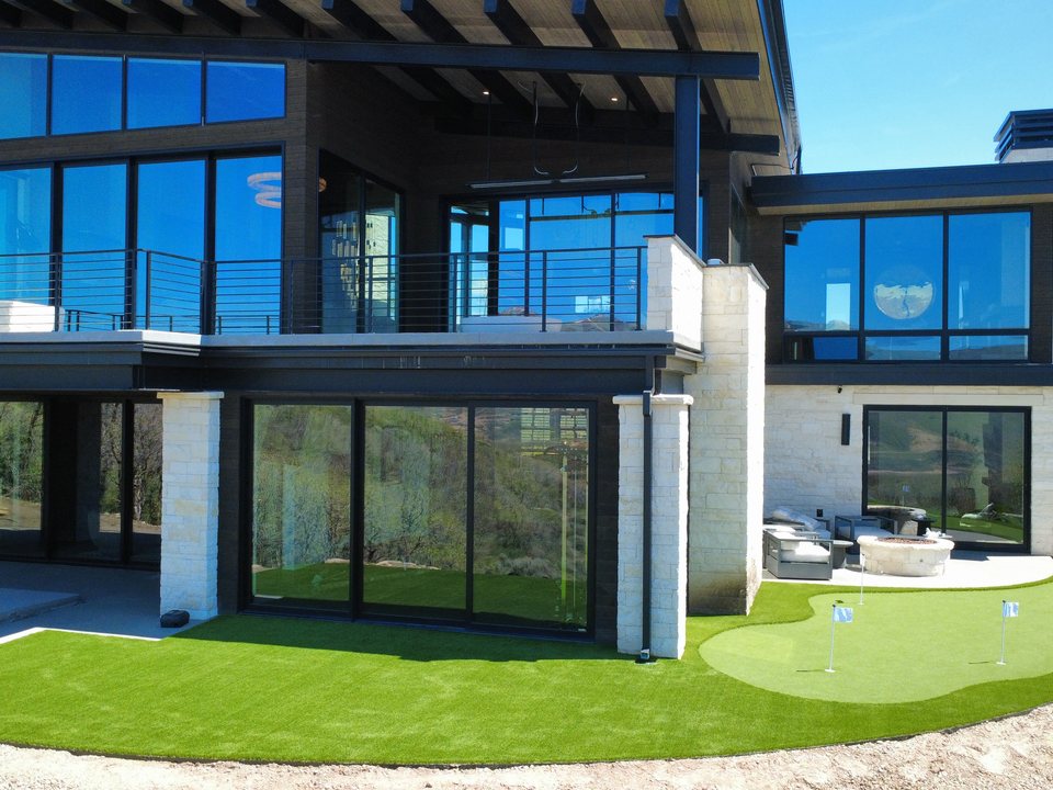 Aerial view of a modern home with a custom putting green