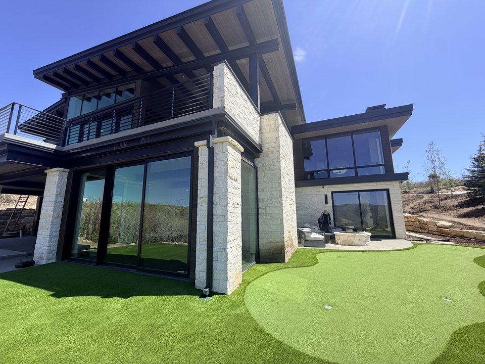 Modern-home putting green with a shaped fringe and cup